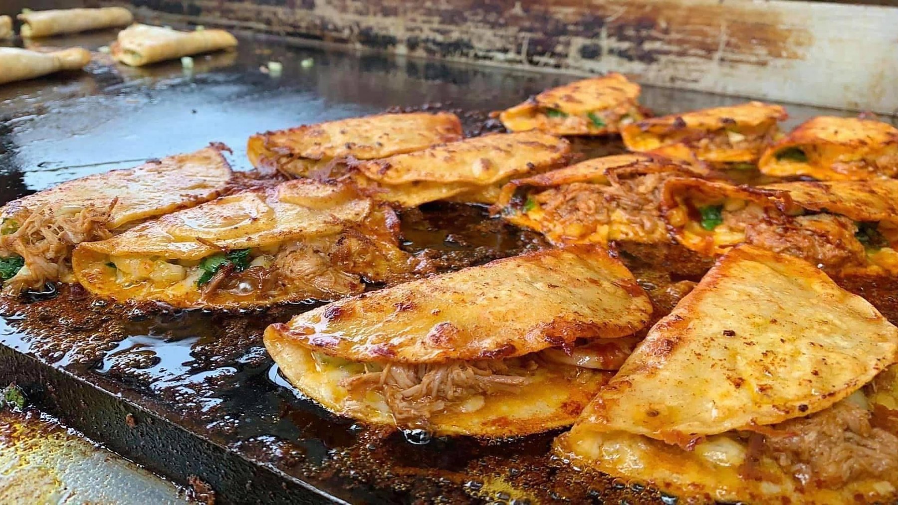 Quesabirria crisping on the griddle at a MaMa E's event